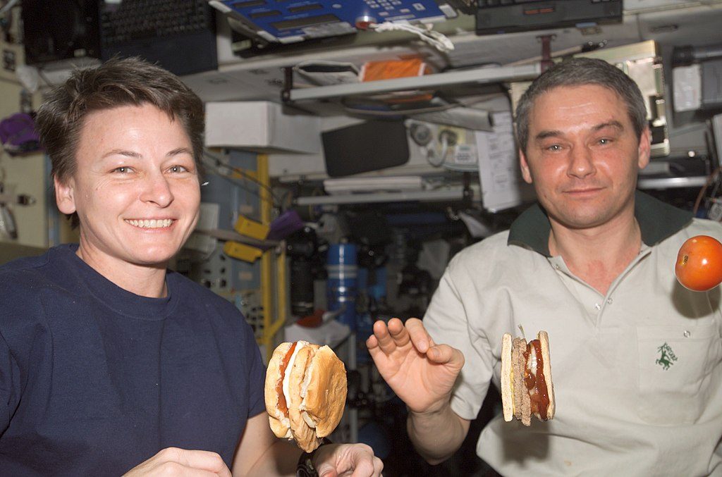 astronautes dégustant un hamburger en orbite